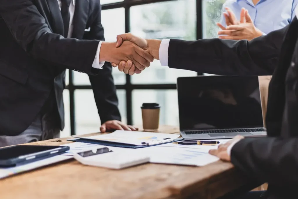 Professionals discussing documents in an office setting, symbolizing negotiation and fair settlement in insurance claims.